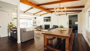 A spacious living area with a wooden dining table, a sofa, and a fireplace. - Family Retreat with Pool and Hot Tub (Vista)