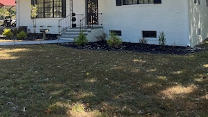 A white two-story house with a dark roof, a chimney, and a front porch with steps. - Beautiful quiet retreat near Oneida, Big South Fork, and ATV trails! (Oneida)