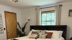 A neatly made bed with white linens, a globe, and patterned pillows. - Beautiful quiet retreat near Oneida, Big South Fork, and ATV trails! (Oneida)