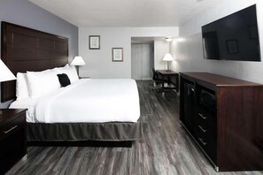Une chambre d’hôtel avec un grand lit, un bureau, une télévision et un minibar.