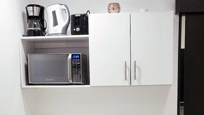 A compact kitchenette with a microwave, coffee maker, and a small refrigerator. - Habitación Independiente #2 , Entre Airport y SJ, Privada (Uruca)