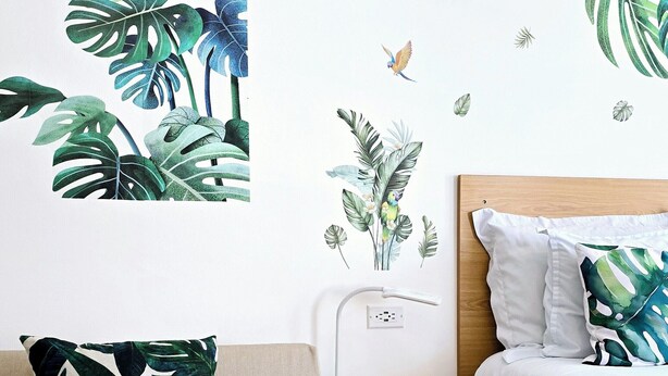 A bedroom with a bed, a nightstand, a lamp, and a wall with a tropical leaf and bird mural. - Habitación Independiente #2 , Entre Airport y SJ, Privada (Uruca)