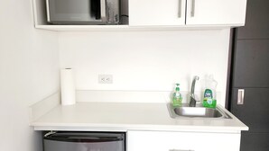 A compact kitchenette with a microwave, coffee maker, and a dishwasher. - Habitación Independiente #2 , Entre Airport y SJ, Privada (Uruca)