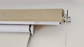 A white wall with a beige textured panel and a white object, possibly a piece of furniture, against it.