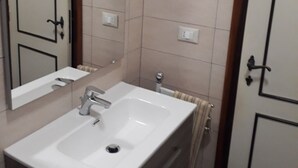 A bathroom with a white sink, a mirror, and a towel rack. - Beach and relax. history and events. Everything at your fingertips. (Francavilla al Mare)