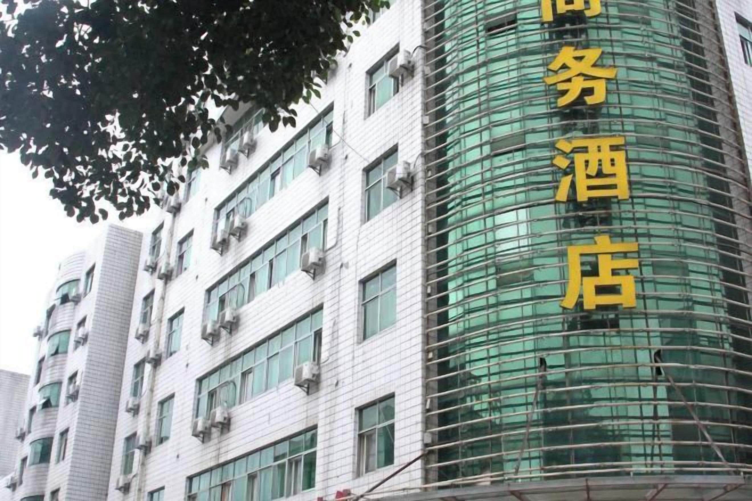 Un hotel de varios pisos con un letrero vertical llamativo que indica su nombre.