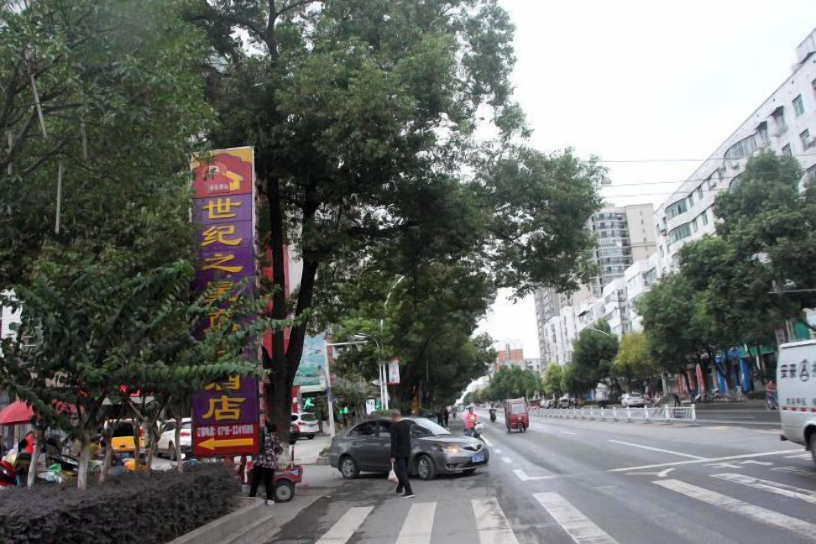 Une scène de rue avec une grande banderole jaune bien visible, faisant la publicité d’un hôtel.