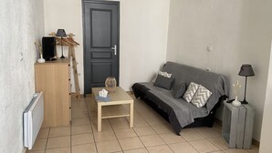 Een knus zithoekje met een bank, een tafeltje, een deur en een radiator.