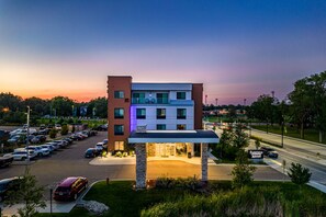 Un hôtel à plusieurs étages, avec un parking à l’avant, le logo Marriott et une vue sur les environs.