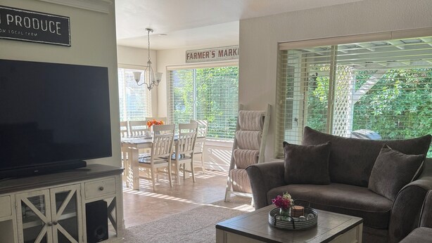 A living room with a television, a ceiling fan, and a sign that reads "PRODUCE ON LOCAL FARM."