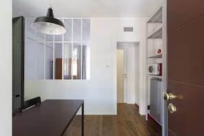 A modern kitchen with a microwave, a coffee maker, and a cabinet.