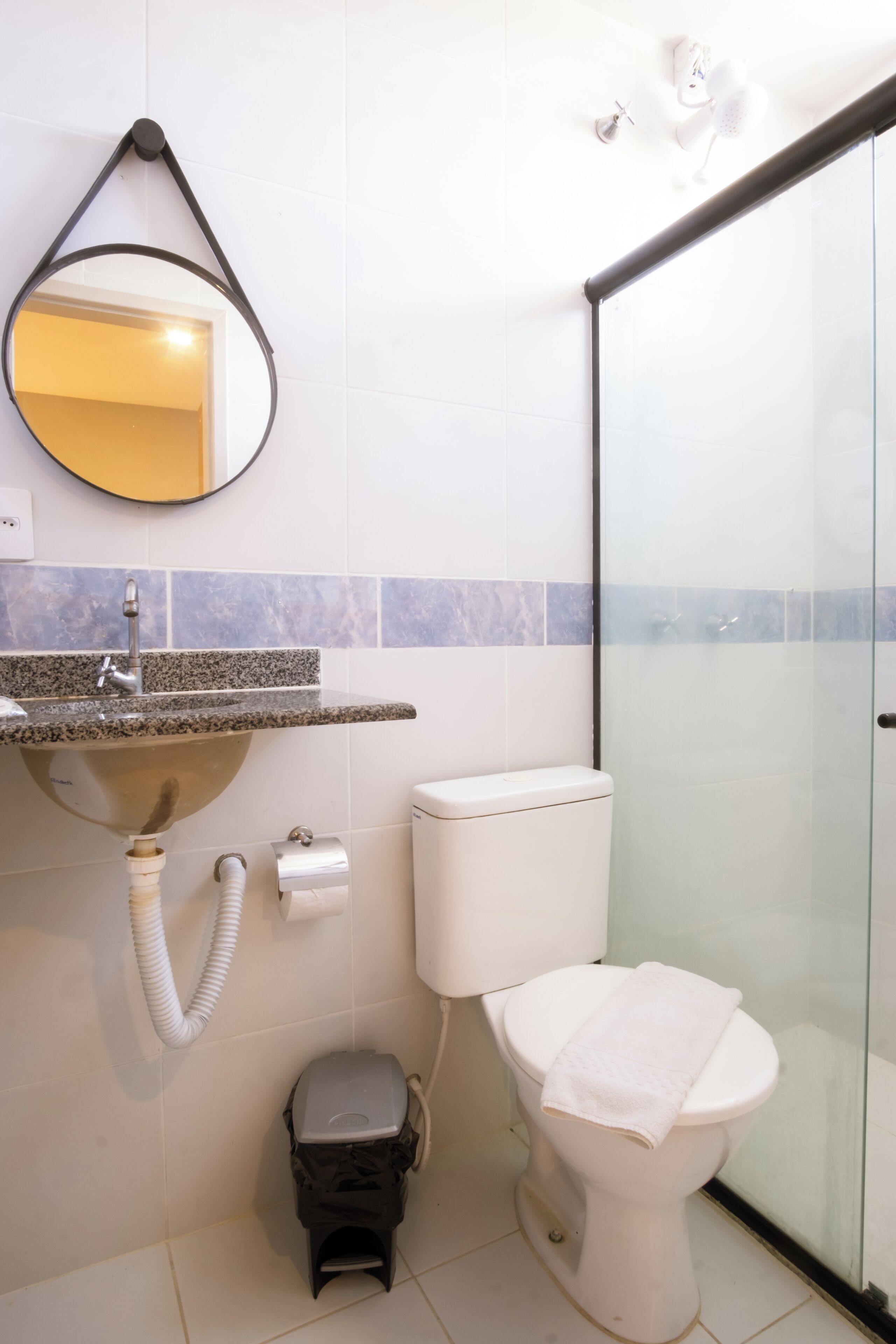 Un baño con lavamanos, inodoro y cabina de ducha de vidrio.