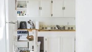 A kitchen with white cabinets, a wooden countertop, and a built-in oven. - Writer’s Farm Cabin: Hot Tub Saunas Farm Animals (San Cristobal)