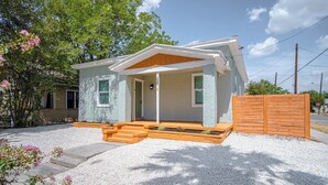 A single-story house with a covered porch, a wooden fence, and a gravel driveway. - Cozy and Lovely 2BR 2BA Apt#a Near Lively Downtown (San Antonio)