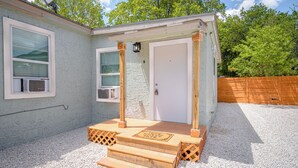 A small, single-story building with a white door and a window with blinds. - Cozy and Lovely 2BR 1BA Apt#b Near Lively Downtown (San Antonio)