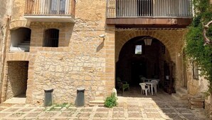 A stone building with a balcony, an archway entrance, and outdoor seating. - Rustic Sicilian hamlet area Partinico / Alcamo/ Balestrate (Partinico)