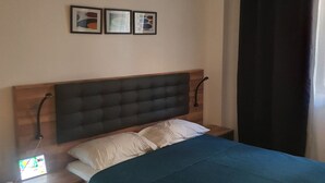 A bedroom with a bed, a nightstand, a lamp, and a window with curtains. - My home in Tangier (Tanger)