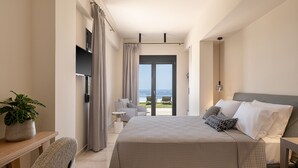 A bedroom with a bed, a desk, a chair, a potted plant, and a view of the outdoors. - Villa Heora - The Floating Residence (Tria Monastiria)