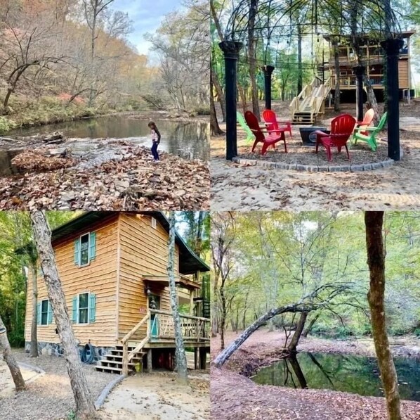 Un chalet rustique avec une façade en bois, une véranda dotée de chaises rouges et un environnement naturel agrémenté d’arbres et d’un plan d’eau.