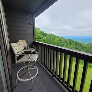 Enjoy the serene view of the lush landscape from this balcony.