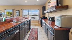 Una cocina moderna con una isla grande, electrodomésticos integrados y vistas a un lago.