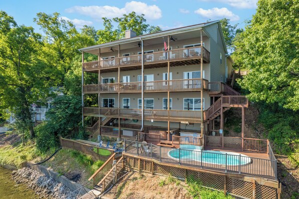 Un edificio a più piani con balconi, piscina e zona solarium.