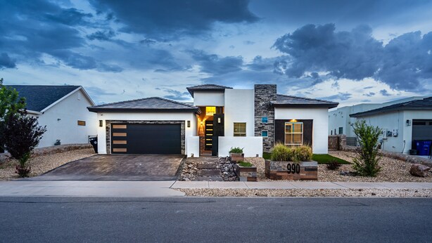 A modern two-story house with a garage, stone facade, and a well-maintained front yard. - VILLA WITH MASTER SUITE CLOSE TO SHOPPING 4 BR 3BA (EL PASO)