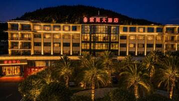 A multi-story hotel with a prominent entrance, surrounded by palm trees.