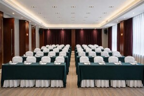 A conference room with rows of tables, each with a white tablecloth and a white table runner. - Dong'an Ziyuan Hotel (Zishui National Wetland Park High-Speed Railway Station Branch) (Dong'an)