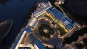 An aerial view of a modern building with a central courtyard, surrounded by roads and a body of water. - Dong'an Ziyuan Hotel (Zishui National Wetland Park High-Speed Railway Station Branch) (Dong'an)