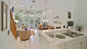A spacious living area with a large island, dining table, and comfortable seating. - Pool + Walk to Duval & Fort Zachary | Monthly Stays | Key West Found (Key West)