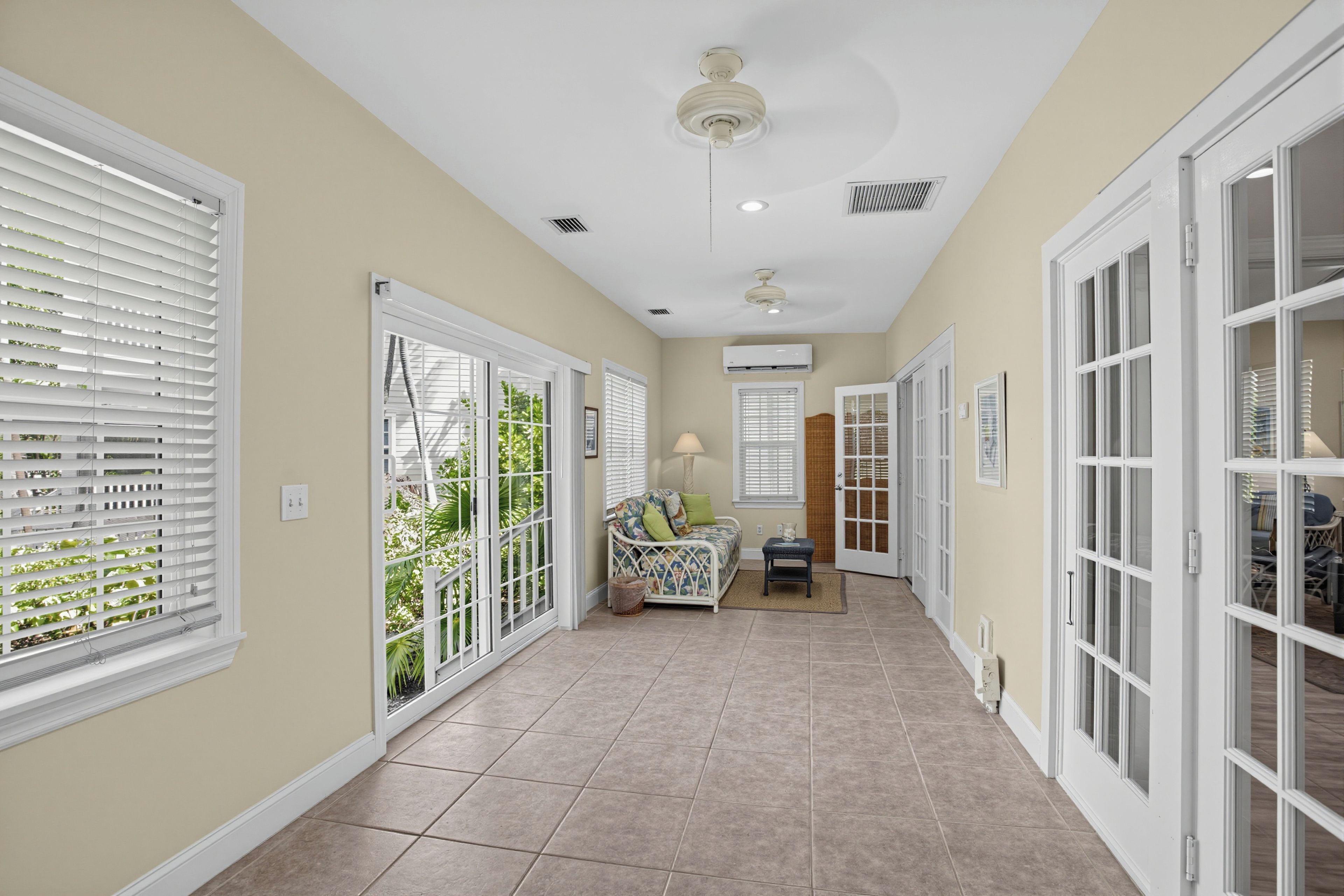 A hallway with a bed, a lamp, and a ceiling fan.