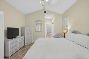 A bedroom with a bed, a television, a wardrobe, a mirror, a door, and a window with blinds. - Place to Relax by AvantStay | Shared Pool | 3 Miles to Smather's Beach (Key West)