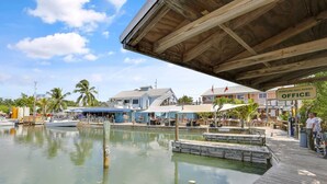 A marina with docked boats, a wooden pier, and a building labeled "Hurricane Hole Marina Office".