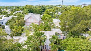 Zona residencial con piscina rodeada de exuberante vegetación y casas.