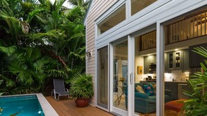 Una casa moderna amb piscina, portes corredisses de vidre i un interior acollidor.