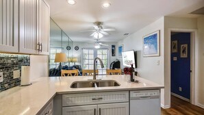 A modern kitchen with a central island, double sink, and built-in dishwasher. - Always Your Paradise | Shared Pool | Near Zachary Beach | Month-Long Stays (Key West)