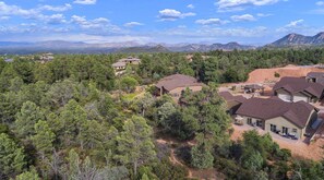 Zona residencial con varias casas rodeadas de un bosque denso y montañas al fondo.