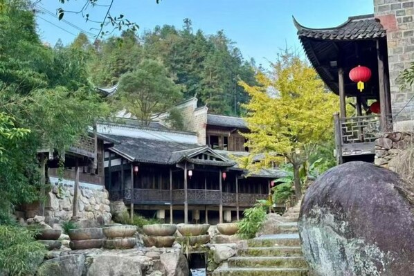 A traditional building with a tiled roof, wooden structures, and stone steps leading up to it.