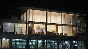 Un bâtiment moderne doté de grandes fenêtres en verre et d’un balcon.