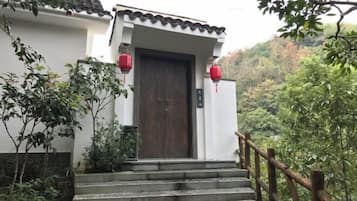 A traditional building with a wooden door, steps leading up to it, and red lanterns.