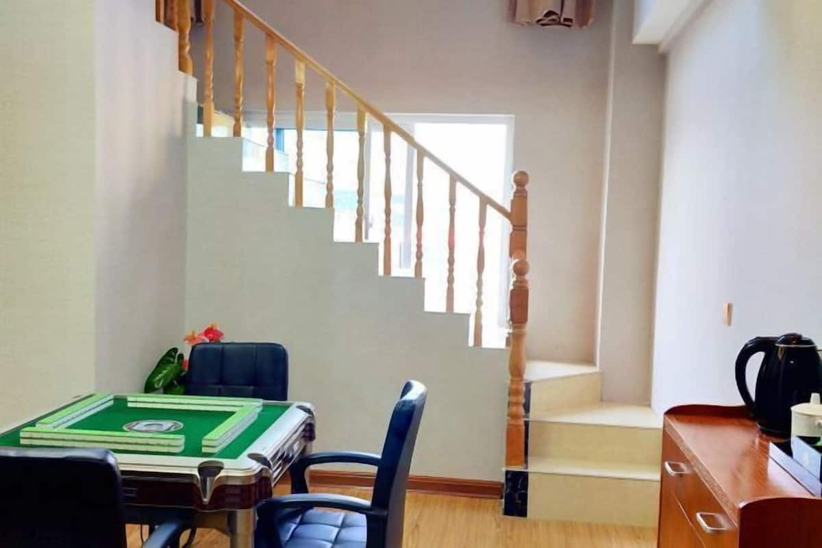 Une pièce équipée d’une table de billard, d’un escalier et d’une machine à café.