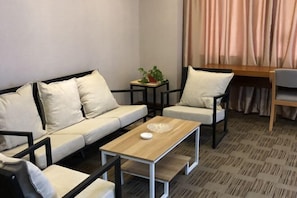 A modern room with a sofa, two chairs, a small table, and a plant. - Siji Zhijia Hotel (Dangshan)