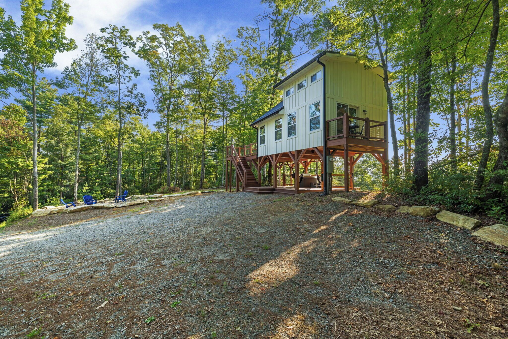 Une cabane dotée d’une terrasse en bois et d’une allée gravillonnée.