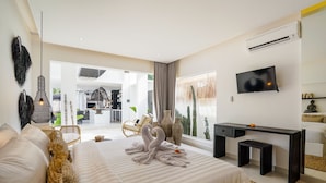 Een moderne hotelkamer met een groot bed, een bureau, een televisie en uitzicht op de omgeving.