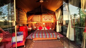 Una habitación acogedora con una cama, una silla roja y una mesita.