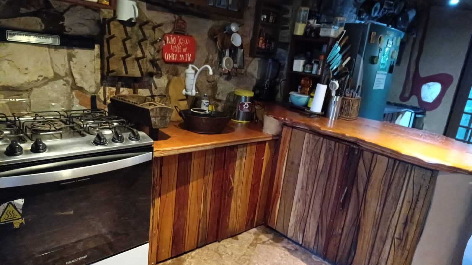A kitchen with a gas stove, wooden cabinets, and various kitchen utensils.