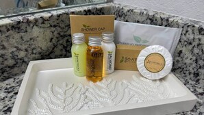 A tray with a shower cap, bottles of shower gel, and a bar of soap on a granite countertop. - Relaxing Hot Tub Home, 2 King Beds, Dog-Friendly, Golf Course (Cape Coral)