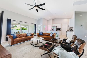 Een moderne woonkamer met een bruine leren bank, een bijzettafeltje en leren fauteuils.