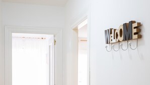 Un intérieur blanc avec une pancarte « BIENVENUE » accrochée au mur.